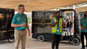 Adil with a UPS team beside an electric delivery vehicle